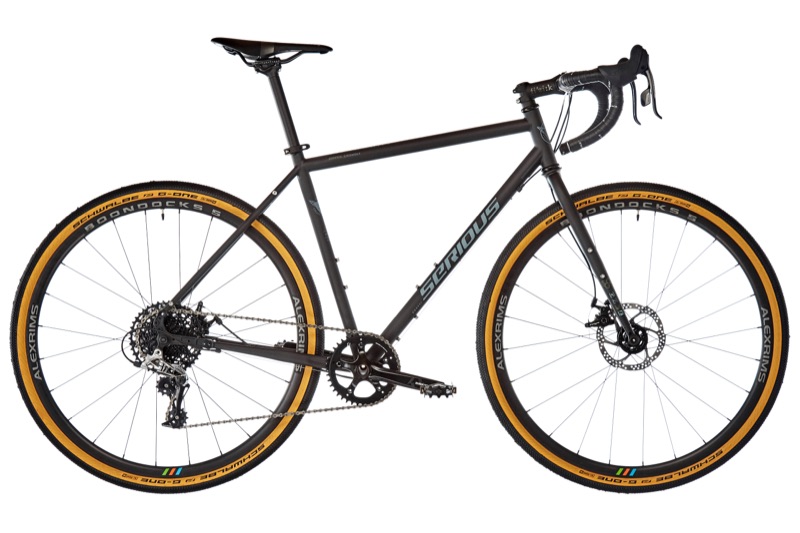 Schwarzes Gravelbike mit Rennlenker und hellbraunen Reifenflanken, Seitenansicht